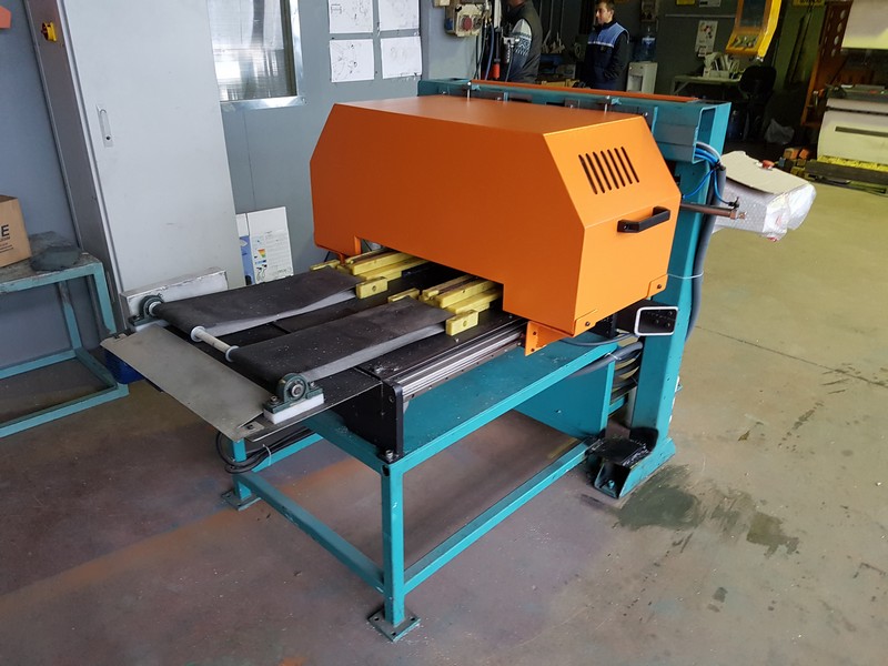 Aluminum cutting machine with conveyor system in a workshop environment