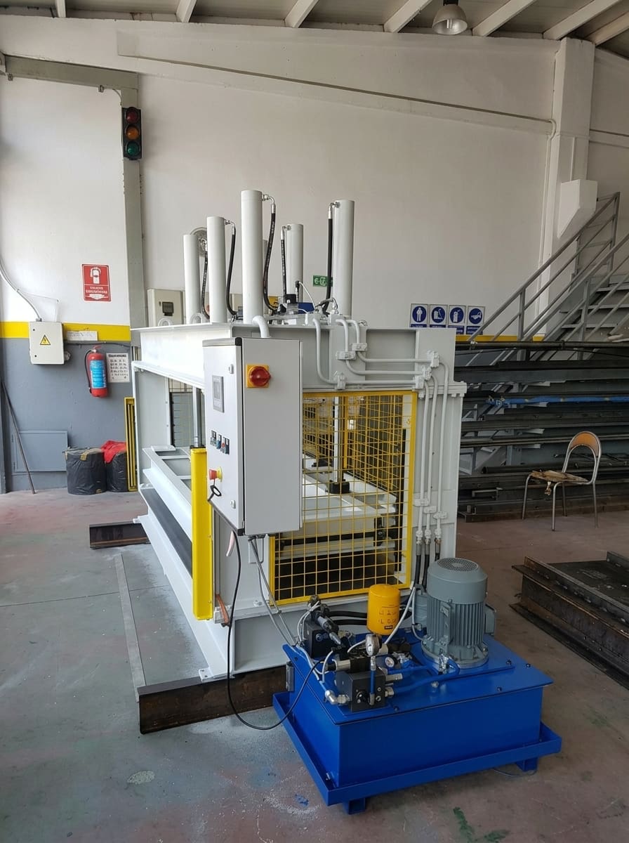 A cold door press machine in a workshop with a blue hydraulic unit.